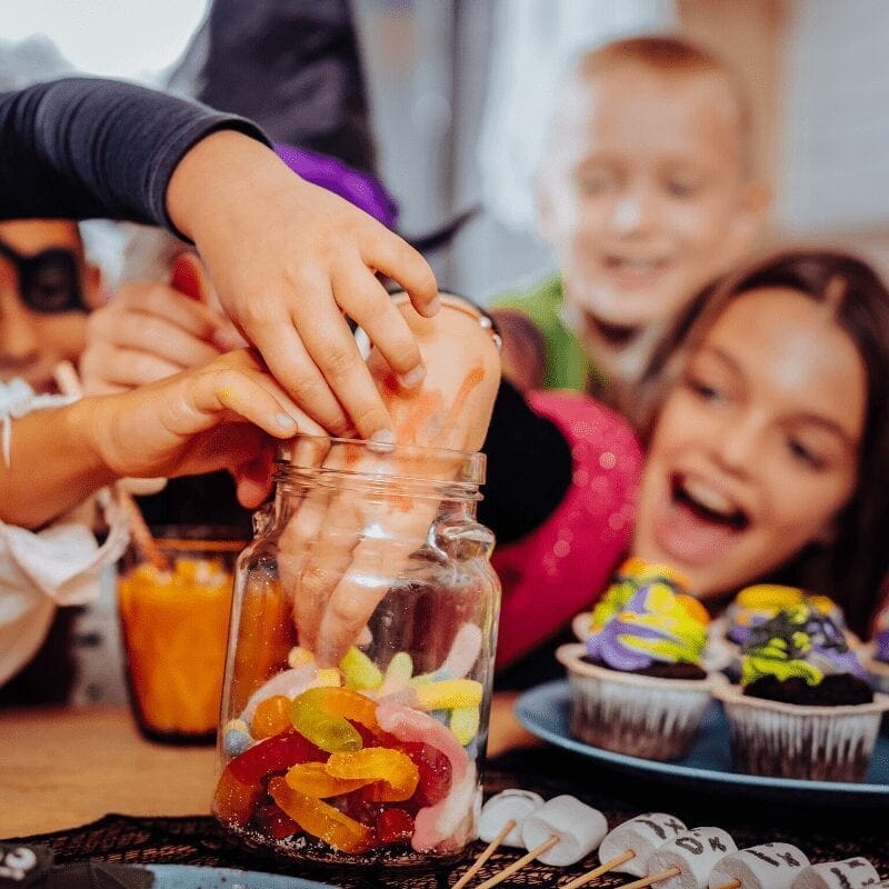  Children getting Halloween candies from a jar.