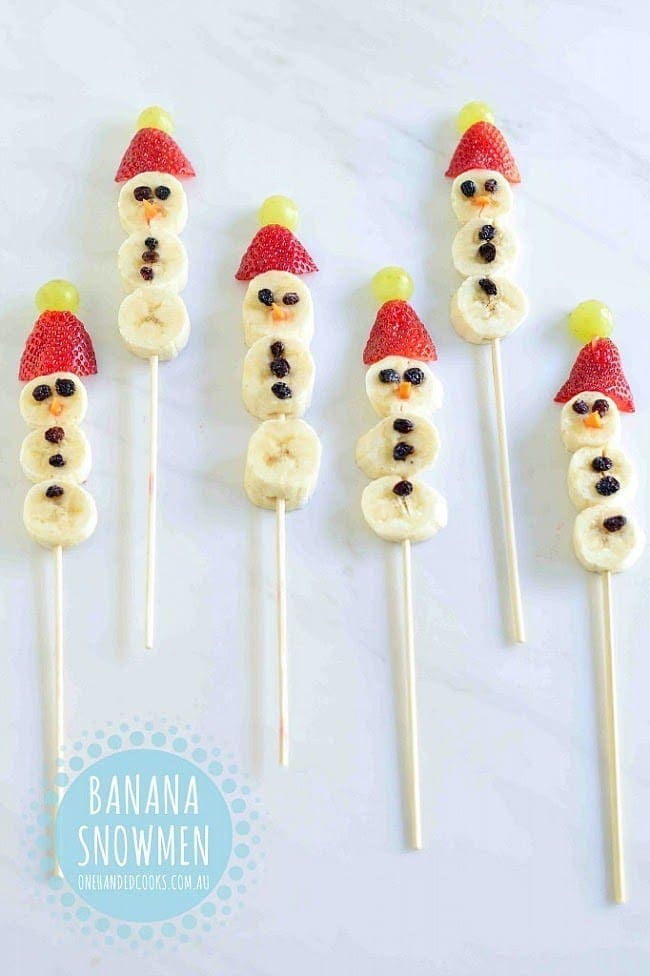 Banana snowmen with raisin buttons and strawberry hats.